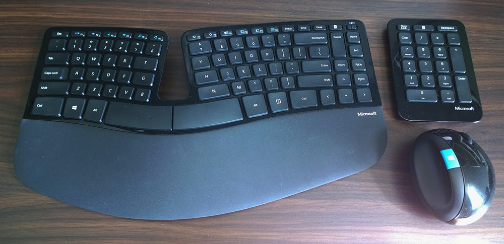 a Microsoft Sculpt keyboard, numpad, and mouse on a desk