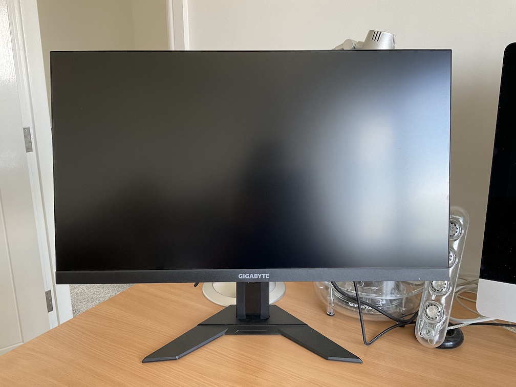 Photo of Gigabyte M28U sat on a desk. The screen is blank
